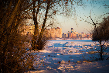 Obraz premium The modern Cathedral of Intercession of the Mother of God, with golden domes, close to the frozen Dnieper River at dawn