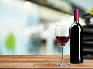Bottle of tasty wine with a glass on the desk