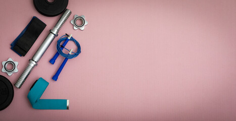 Top view of sport equipment on pink fitness mat with place for text and copy space	