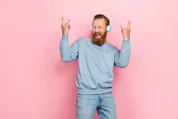 Photo of careless childish person listen song fingers demonstrate heavy metal symbol isolated on...