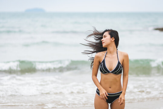 Portrait beautiful young asian woman with black bikini on the beach. Holiday and summer travel concept
