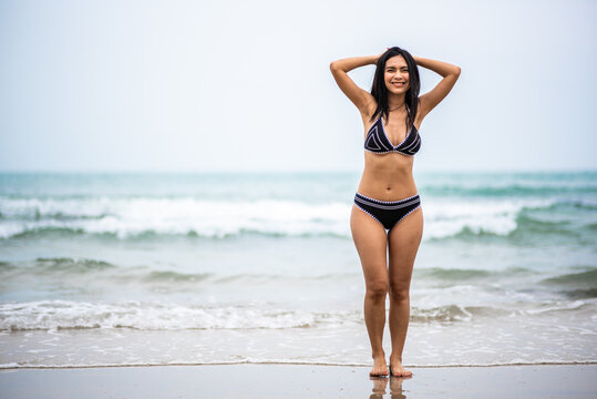 Portrait beautiful young asian woman with black bikini on the beach. Holiday and summer travel concept