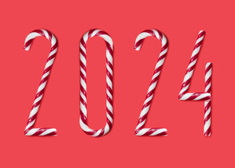 2024 made from sweet caramel canes, candies on red background