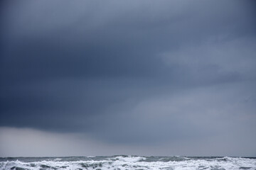 dark cloud in stormy grey sky over rough sea landscape
