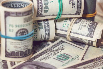 background of rolled-up hundred-dollar bills