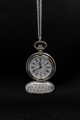 An old pocket watch on black background, copy space