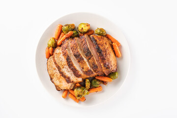 Roast pork loin with herbs and vegetables on white background. Sliced Pork Meat