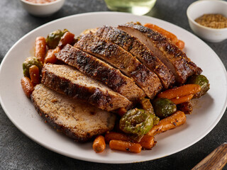 Roasted pork Loin with carrot and broccoli. Sliced Pork Meat. Grey background.