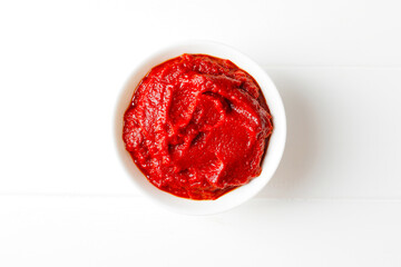 Tomato sauce in white bowl on white wooden background