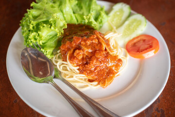 Spaghetti Pasta and tomato sauce Garlic and spices with cheese and fork in a lettuce platter