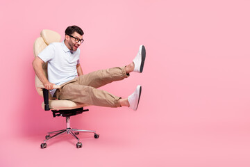 Full length photo of excited guy look copyspace fast ride chair game isolated on pastel color...