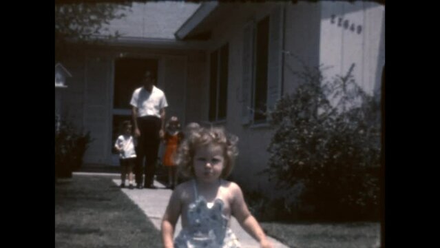 Leaving With Dad 1962 - A father and three children leave the house and the youngest is in a hurry, in Canoga Park, California in 1962.