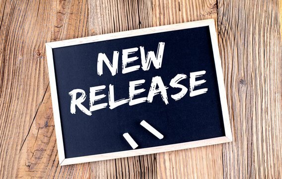 NEW RELEASE text on a chalkboard on the wooden background