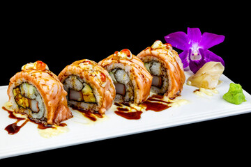 Sushi Roll with Salmon, Cream Cheese, Wasabi, Pickled Ginger decorated with purple orchids On a black background. Sushi menu. Japanese food. © Prayong