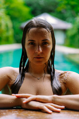 Young woman in a swimming pool on a tropical island.