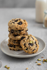 pile de cookies faits maison chocolat noir pistache au goûter avec bouteille de lait
