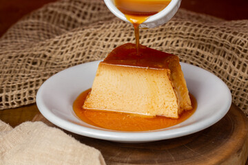 caramel syrup pouring over milk pudding slice.