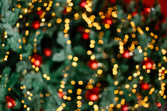 Beautiful background with the spirit of Christmas. Copy space place for text banner. Yellow bokeh against the background of a green Christmas tree. Decoration for the new year. Garlands on spruce gold - Powered by Adobe