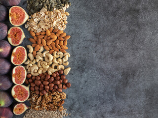 Flat plate with mixed nuts, figs. Top view background with healthy snack on a dark background