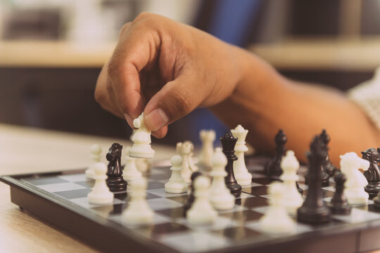 business person play chess game. office people have a break by test brian using puzzle board train in free time. smart employee practice intelligence match chess board in a break desk at workplace