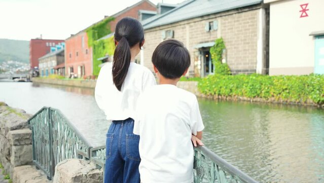 小樽運河を眺めている日本人の男の子と女の子