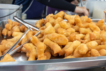 The offer of a deep-fried dough stick at Thai market, close up.