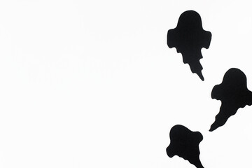 Happy Halloween! Black ghosts decorations on white background. Halloween flat lay. Card template with space for text. Modern minimal border