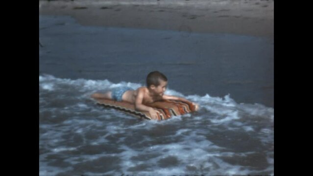 Riding the Surf 1967 - A boy rides the surf on a raft, at El Capitan State Beach in California, 1967. 