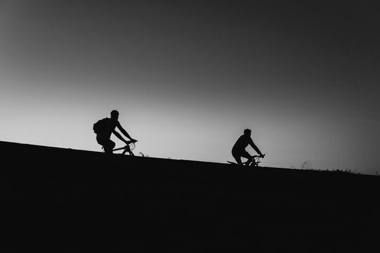 Beautiful Couple on bicycles silhouette sunset two bike ride, black and white