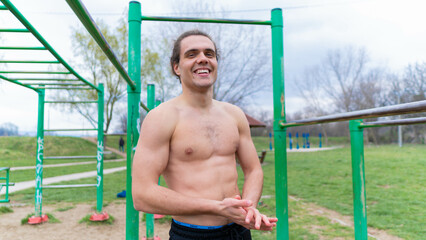 handsome muscular athlete posing in the park where he trains.