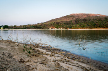 Linda paisagem, com céu azul e limpo, e  montanha ao fundo na praia de água doce da represa da Várzea das Flores, em Contagem, Minas Gerais, Brasil.