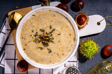 Homemade roasted chestnut soup. Autumn cream soup with chestnuts on black background