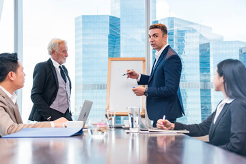 businessman will wrtie and explane business deal on whiteboard  at skyscraper office lounge with cityscape business zone background