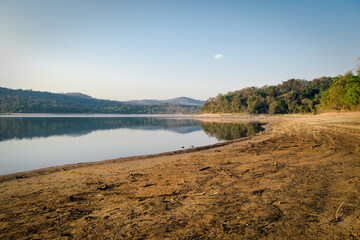 Lindo amanhecer, em época de seca, céu azul e limpo, com vista para a praia de água doce da represa da Várzea das Flores, em Contagem, Minas Gerais, Brasil.