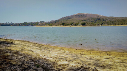 Lindo amanhecer, em época de seca, com céu dourado e limpo e neblina na praia de água doce da represa da Várzea das Flores, em Contagem, Minas Gerais, Brasil.