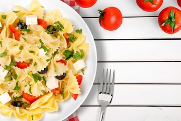 Italian pasta salad with cheese, tomato, mushroom and fresh vegetables.