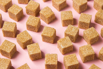 Cane sugar on a pink background. Brown refined cane sugar.	