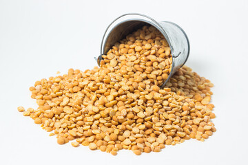Yellow dried peas in a small steel pail on a white background. Delicious and nutritious cereal