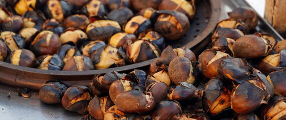 Grilled Chestnuts. Roasted Street Food. Snacks for tourists in Istanbul, Turkey. Selective Focus. Wide Banner. Panoramic Photo