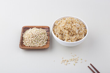 Brown rice in white rice bowl isolated on white background.