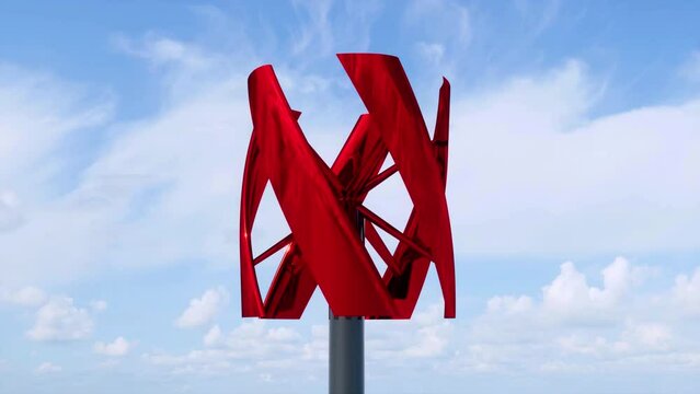 A close-up view of a red-colored, anodized, vertical axis wind turbine generating electricity from the wind during the day.