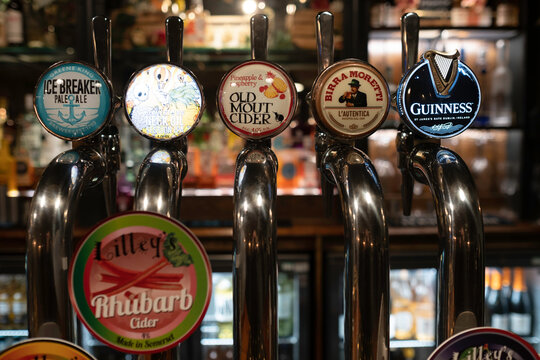 BURY ST. EDMUNDS, UK - SEPTEMBER 08 2022: Stainless steel beer taps in an English pub with different types and brands of beers and drinks. Narrow depth of field