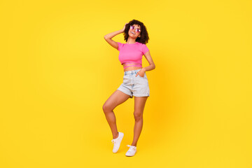 Fototapeta na wymiar Full length photo of cute sweet lady wear pink top dark eyewear laughing empty space isolated yellow color background