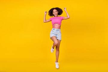 Full length photo of funky brunette young lady jump wear top shorts boots isolated on orange color background