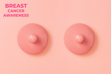Two pink ceramic lids on a pink background symbolizing the female breast. Flat lay. Concept of Breast Cancer Awareness Month