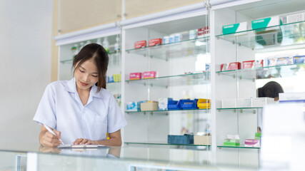 Fototapeta na wymiar Pharmacist working in a pharmacy, Consultation and medical advice, All kinds of generic household drugs and pharmaceutical products on the shelf, Service and assistance to patients, Pharmacy.