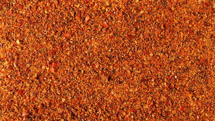 Seasoning preparation, mild hot powder mixture, with spices and tomatoes, (black pepper, garlic, cane sugar, granulated tomatoes, cayenne pepper, sea salt) background and texture 