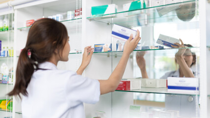 Pharmacist picks up pills on shelf from doctor's prescription, All kinds of generic household drugs...