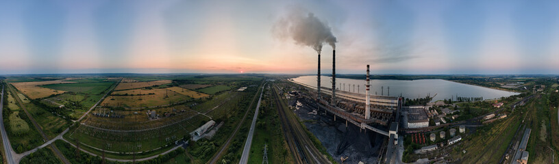 Aerial view of coal power plant high pipes with black smokestack polluting atmosphere. Electricity production with fossil fuel concept