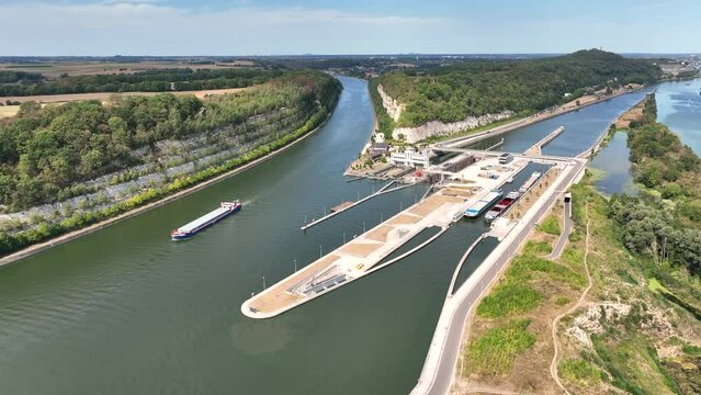 Freight ships sailing on the Albert Canal towards Liege close to the river Meuse and the Lanaye locks. Drone point of view.